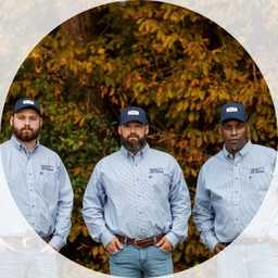 three quality pest services staff members in front of tree
